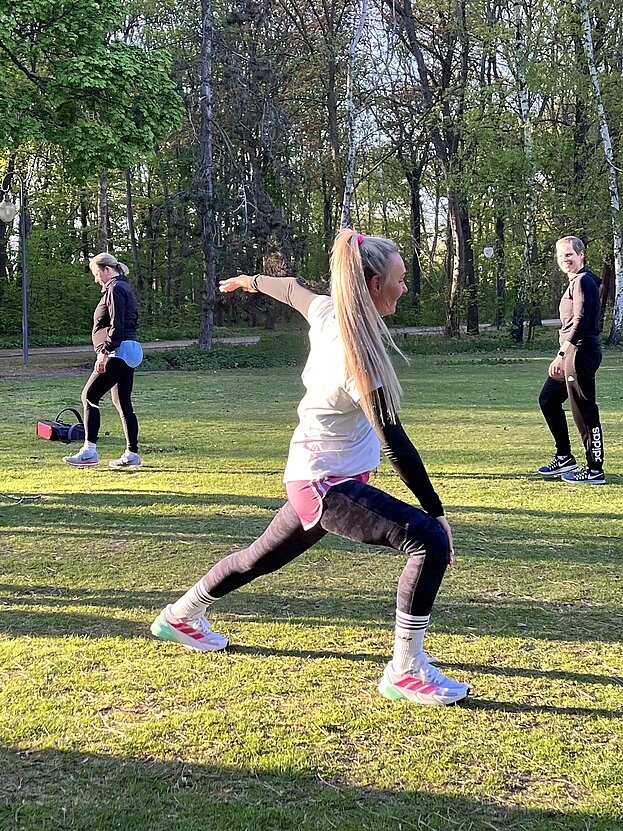 Frau dehnt sich auf Wiese © SCC EVENTS