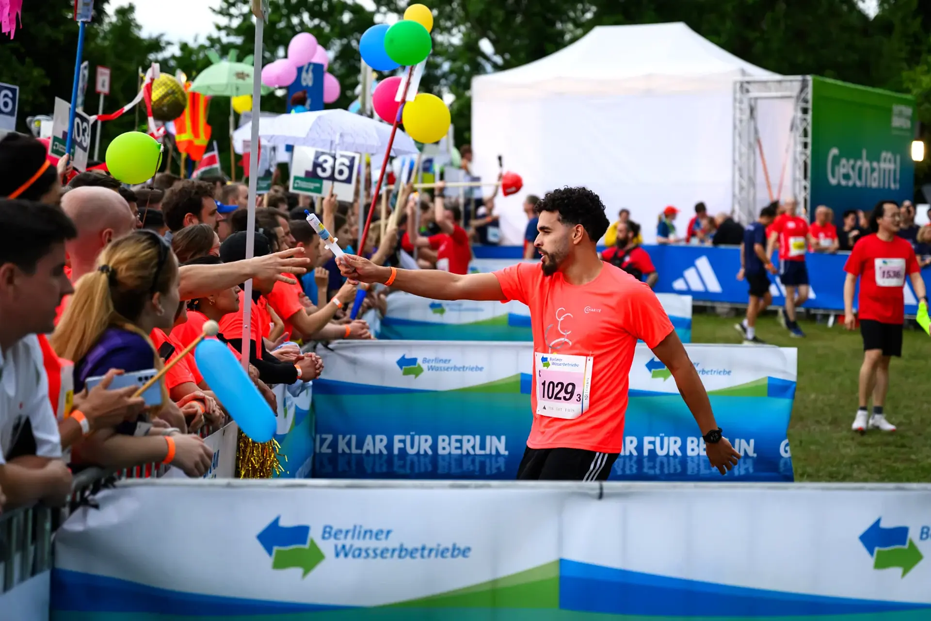 Eine Spritze, die als Staffelstab dient, wird in der Wechselzone übergeben.