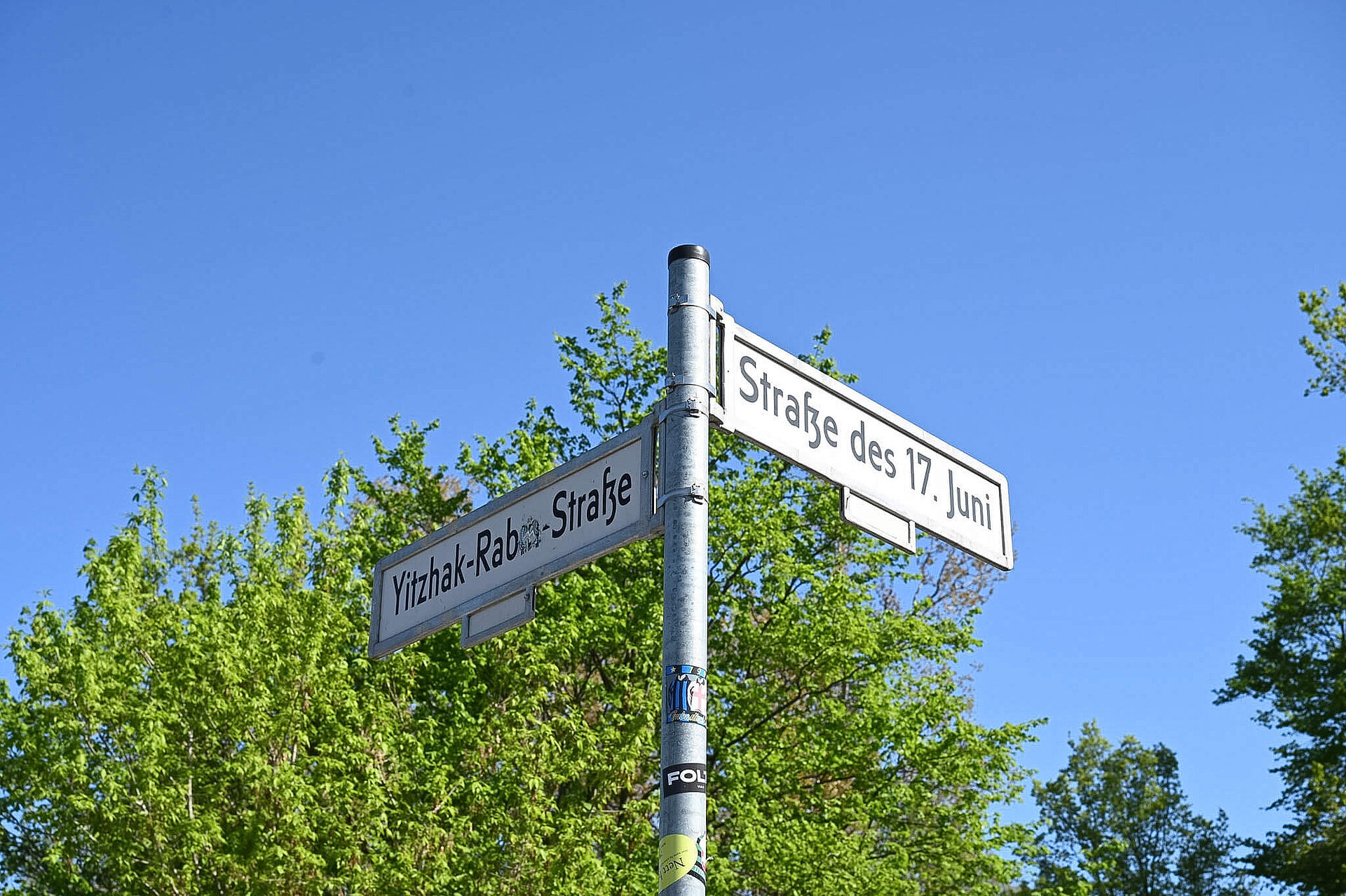 Street signs for Straße des 17. Juni and Yitzhak Rabin Street.
