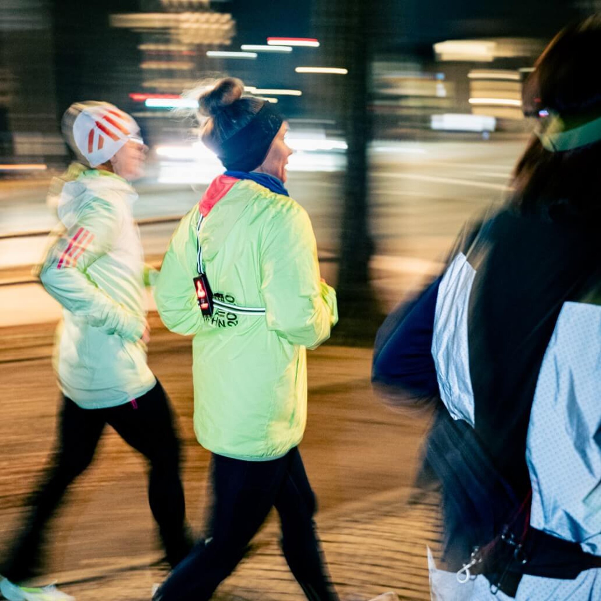 Drei Teilnehmerinnen beim Laufen. Das Bild weist Bewegungsunschärfe auf, um Dynamik und Energie auszustrahlen.