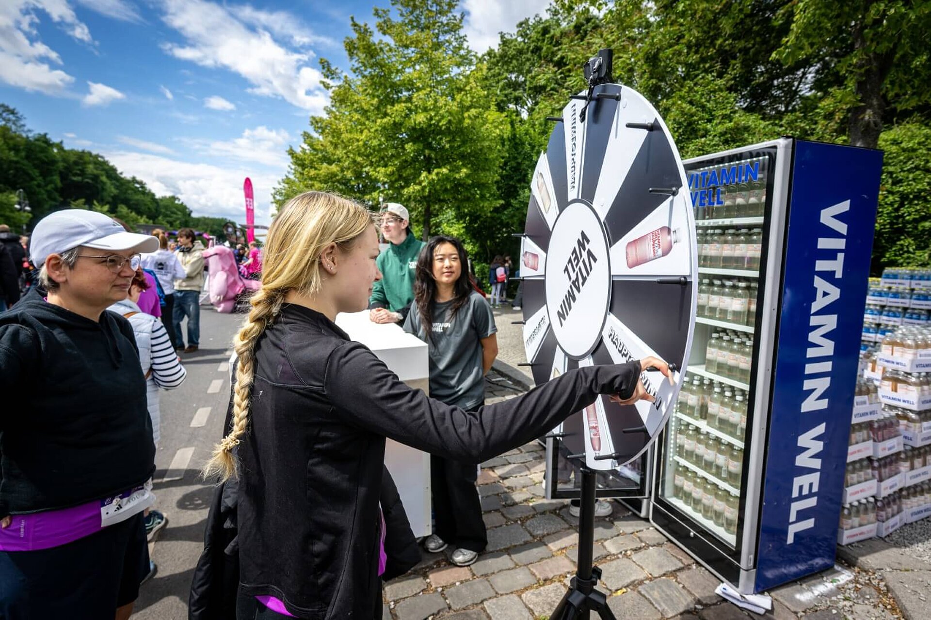 Junge Frau dreht Glücksrad von VITAMIN WELL.